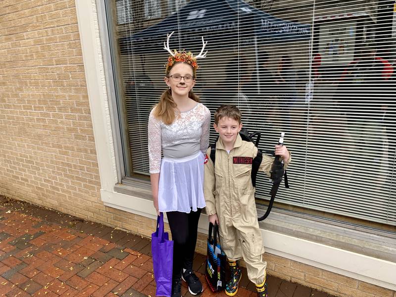 Siblings Margaret Matthiesen, 13, and Ghostbuster William Matthiesen, 9, pose while trick-or-treating during the 26th annual Spooktacular event in downtown DeKalb Thursday, Oct. 26, 2023 hosted by the DeKalb Chamber of Commerce.