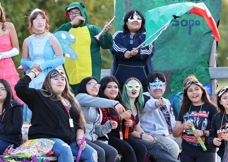 Members of the DeKalb High School Spanish Club throw candy to parade attendees as they head down Dresser Road Wednesday, Oct. 5, 2022, during the school's homecoming parade.