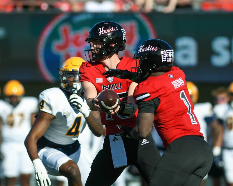 Northern Illinois Huskies quarterback Josh Holst (15) hands the ball off to Antario Brown (1) during the game on Saturday Oct. 19, 2024, held at Northern Illinois University.