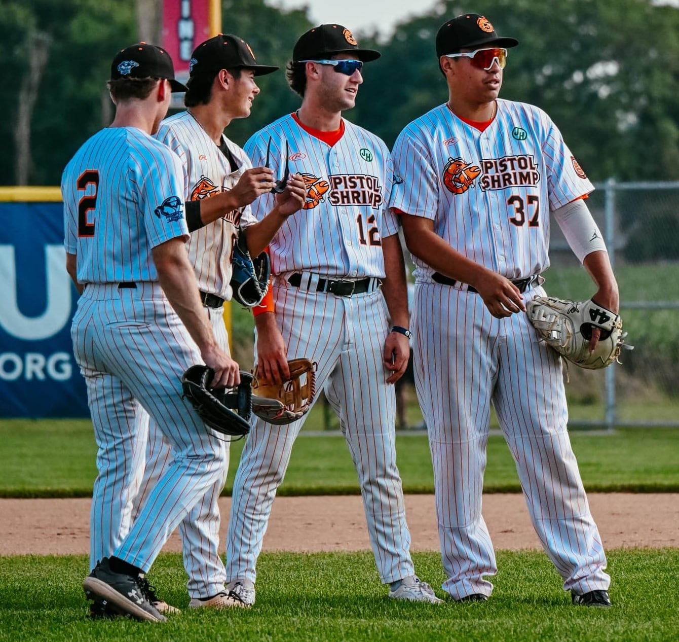 Illinois Valley Pistol Shrimp players Chance Resetich, Kyle Gibson, Ryan Niedzwiedz and Makana Olaso talk during a game against the Chillicothe Paints on Sunday, July 28, 2024 at Schweickert Stadium in Peru.