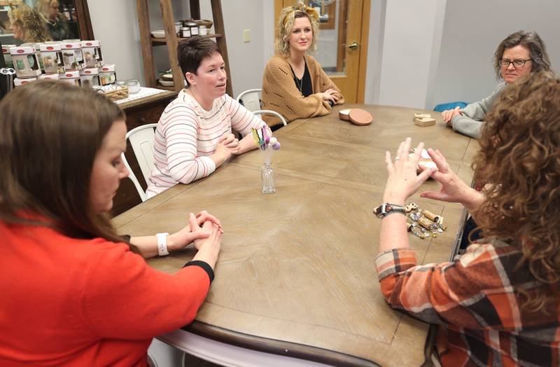 Joni Peterson, (second from left) owner of 35:35 Makers Collective, talks Friday, March 18, 2022, to local artisans who will have their work available for purchase in the shop. The store, at 308 West State Street in Sycamore, is scheduled to open April 1.