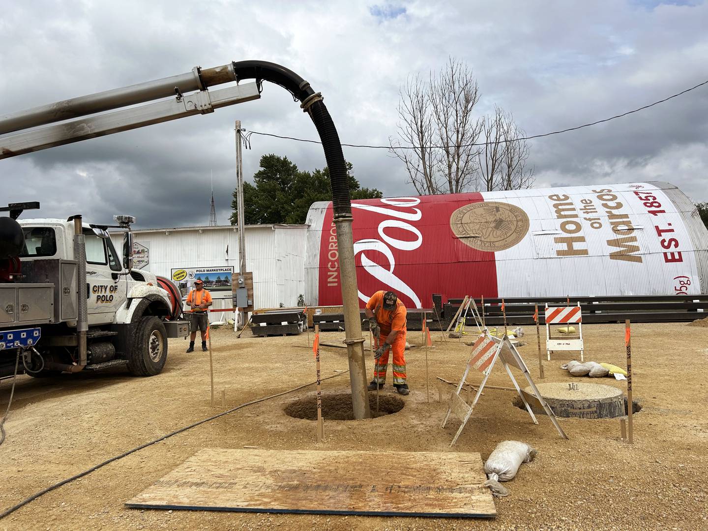 Polo city employees work to prepare the city-owned lot at 212 S. Division Ave. for the erection of two pavilions.