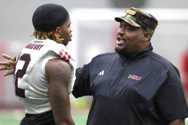 Northern Illinois University football head coach Thomas Hammock talks to receiver Kenji Lewis Tuesday, March 26, 2024, during spring practice in the Chessick Practice Center at NIU.