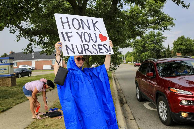 Megan Jessen can be seen holding a sign while picketing Wednesday, July 8, 2020, outside AMITA Health Saint Joseph Medical Center Joliet in Joliet, Ill.