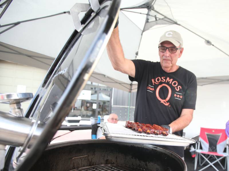 Tom Mayheu of Hennepin, places his ribs inside the cooker during the BBQ and Blues festival on Friday, Sept. 13, 2024 downtown La Salle.