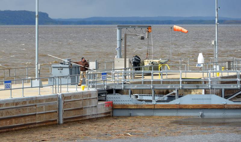 A worker at Lock & Dam 13, between Thomson and Fulton, uses a long metal rod to push debris away from the north gate of the lock on Saturday, April 22. Mississippi River levels were expected to continue to rise and possibly crest at 22' this week.