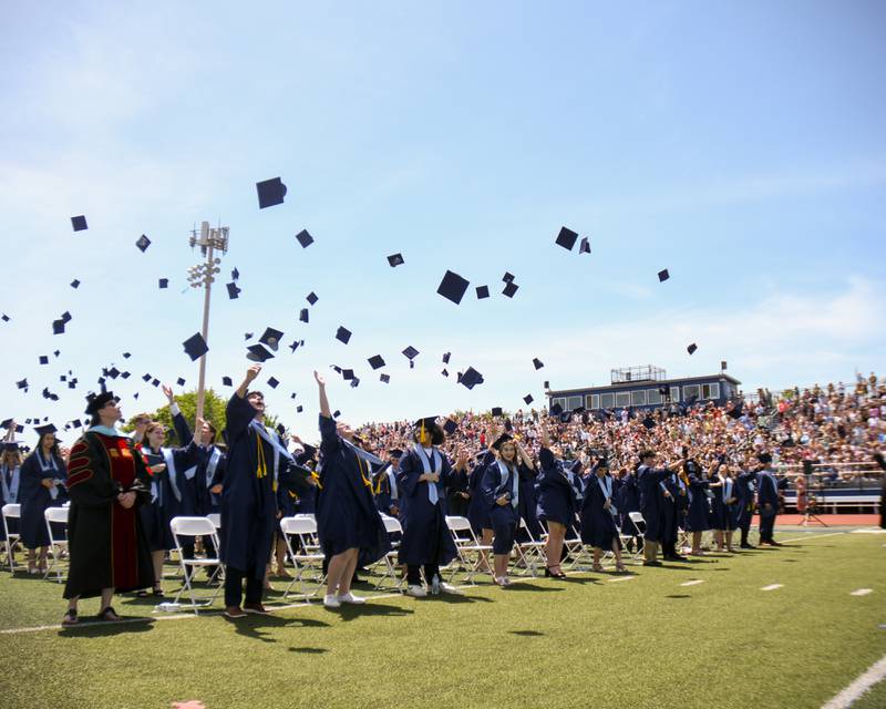 Downers Grove South graduates throw their caps in the air at the end of the graduation ceremony on Sunday May 19, 2024, held at Downers Grove South High School.