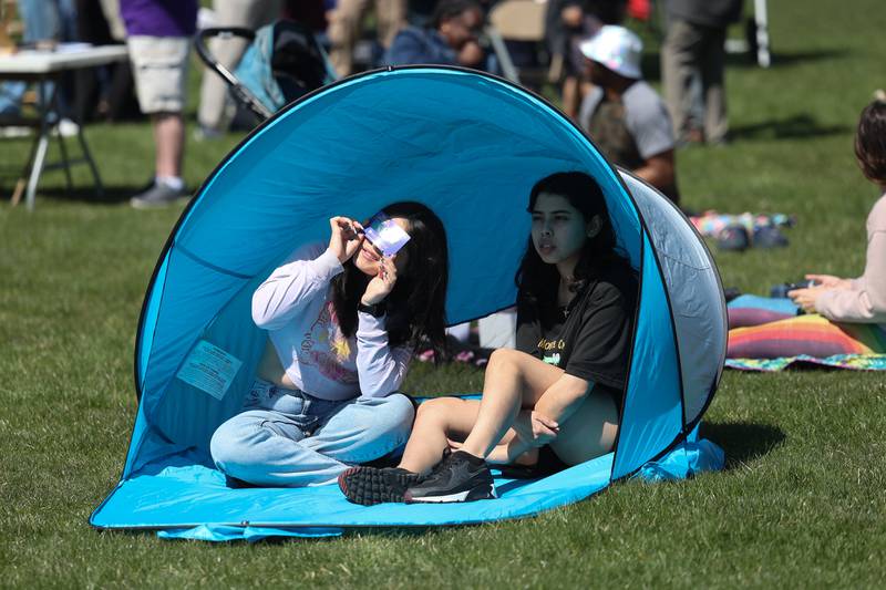 A couple put up a small tent for the eclipse viewing at the Joliet Junior College solar eclipse viewing event on Monday, April 8, 2024 in Joliet.