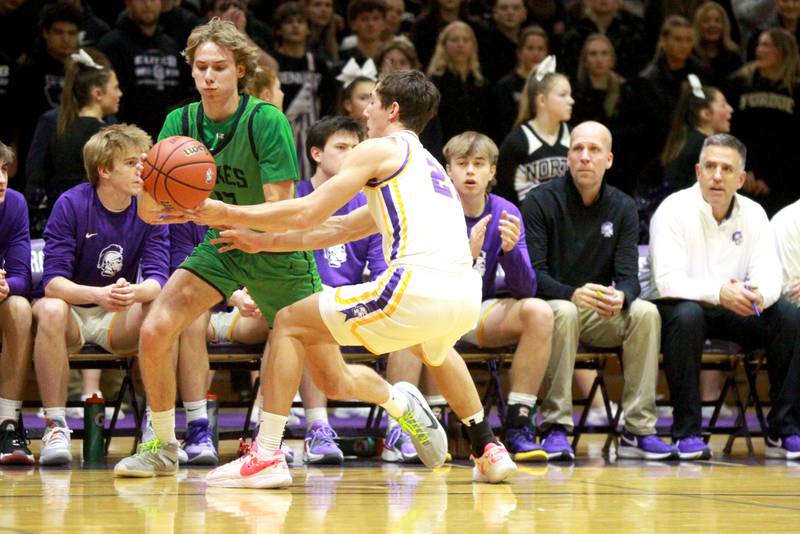 York’s Brendan Molis (left) gets the ball batted away by Downers Grove North’s Jack Stanton during a game at Downers Grove North on Friday, Jan. 19, 2024.