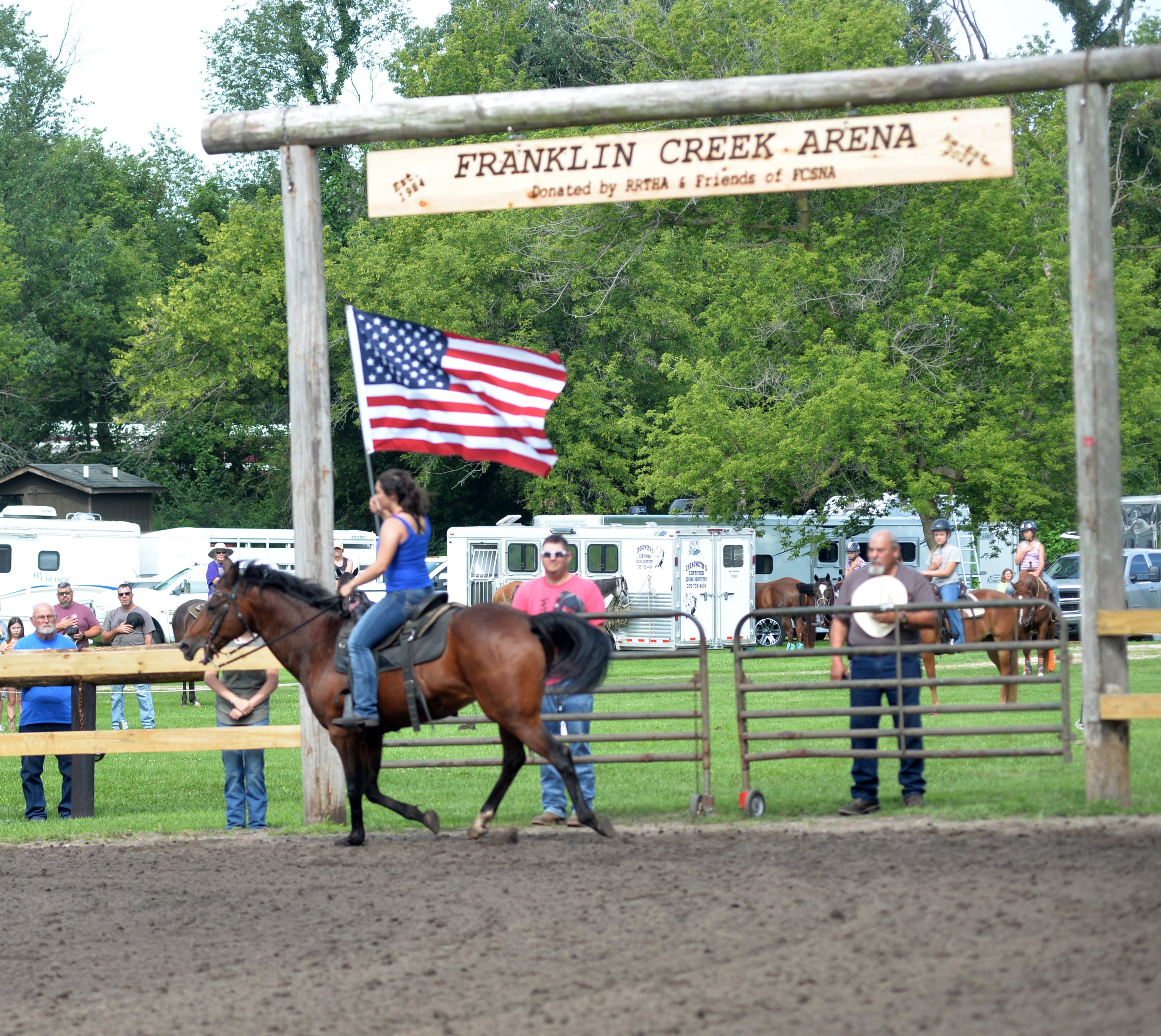 Evie Helton of Sycamore and a member of the Ogle County 4-H Horse Drill Team, carries the American flag as the National Anthem is played at the start of the Rock River Trail & Horseman Association's Grand Opening Show on Saturday, July 20, 2024. The show was held in the newly refurbished horse arena located in Franklin Creek Natural Area, just north of Franklin Grove.