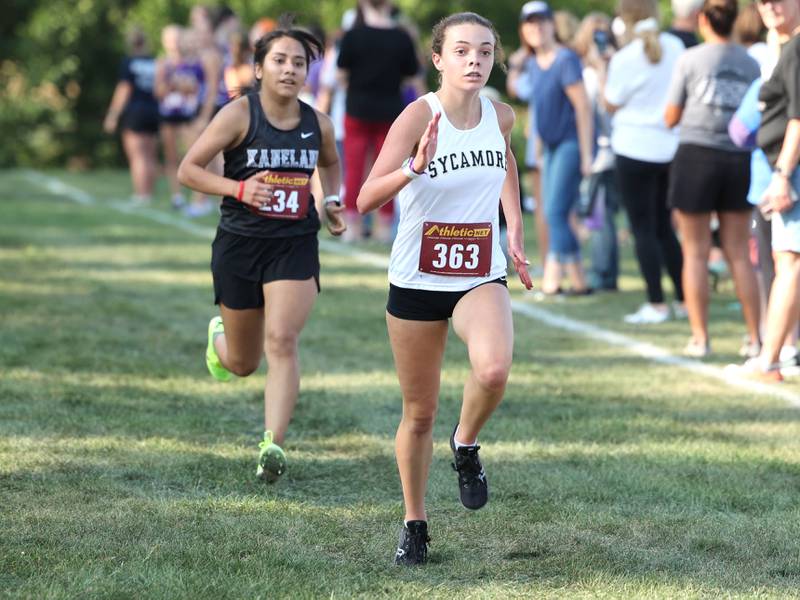 Sycamore’s Layla Janisch edges out Kaneland’s Jade Unzueta during the Sycamore Cross Country Invitational Tuesday, Aug. 29, 2023, at Kishwaukee College in Malta.