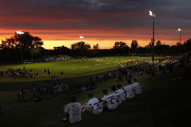 Prairie Ridge junior varsity players watch the Prairie Ridge Jacobs game as the sun sets during a Fox Valley Conference football game on Friday, Aug 30, 2024, at Jacobs High School in Algonquin.