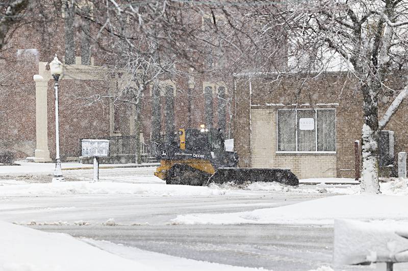 Snow clearing equipment works in a downtown Sterling parking lot Tuesday, Jan. 9, 2024 as the first big snow fall of the winter socks the Sauk Valley.