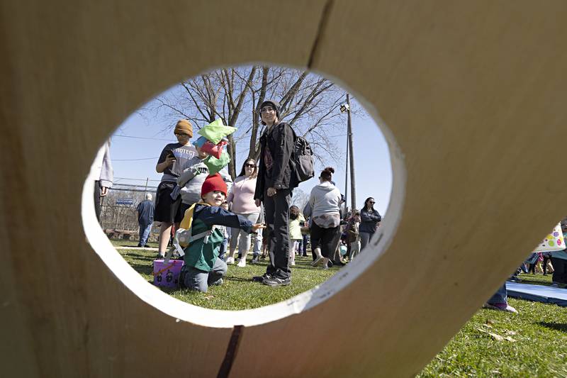 Sedrick Oliver, 2, fires a fistful of bean bags through a hole Thursday, April 6, 2023. Before the hunting began with the Dixon Park District, kids could play games and hang with the Easter Bunny.