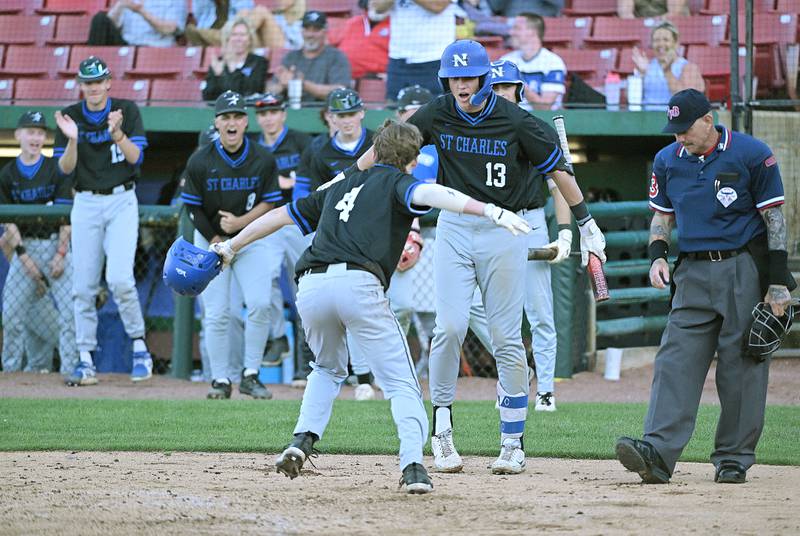 St. Charles North’s Ty Heimbuch and his teammates celebrate scoring against St. Charles East in the third game of their inter-city series at Northwestern Medicine Field in Geneva on Tuesday, April 20, 2024.