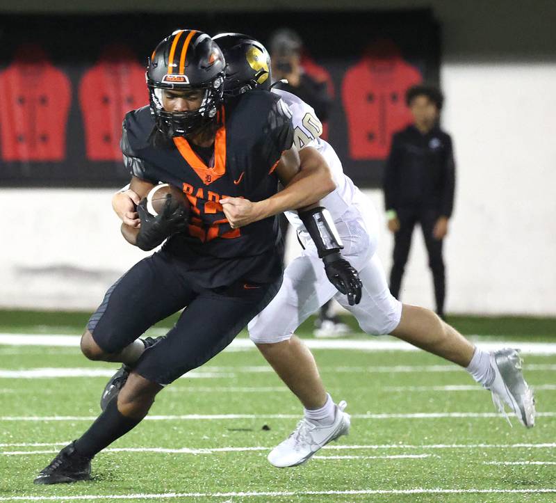 DeKalb's Derrion  Straughter tries to get away from Sycamore's Caden Wicks Friday, Aug. 30, 2024, during the FNBO Challenge at Huskie Stadium at Northern Illinois University.