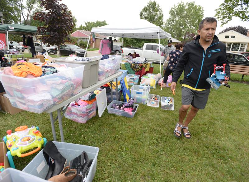 Jorge Olivan of Berwyn picks out some kids toys during the Berwyn Garage Sale Saturday July 8, 2023.