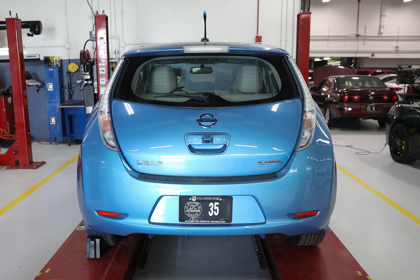 A Nissan Leaf electric vehicle sits on a lift before getting serviced at the Joliet Junior College automotive department on Thursday, Feb. 1, 2024.