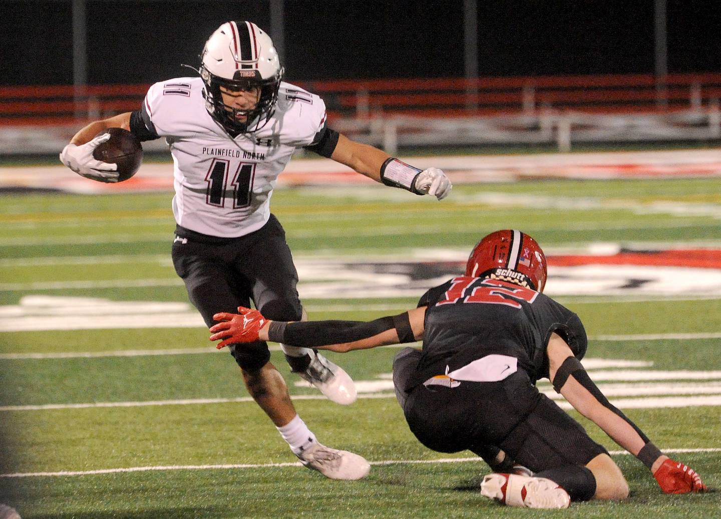 Plainfield North receiver Omar Coleman (11) gets yards after a catch against Yorkville defender Jack Ferguson (12) during a varsity football game at Yorkville High School on Friday, Oct. 20, 2023.