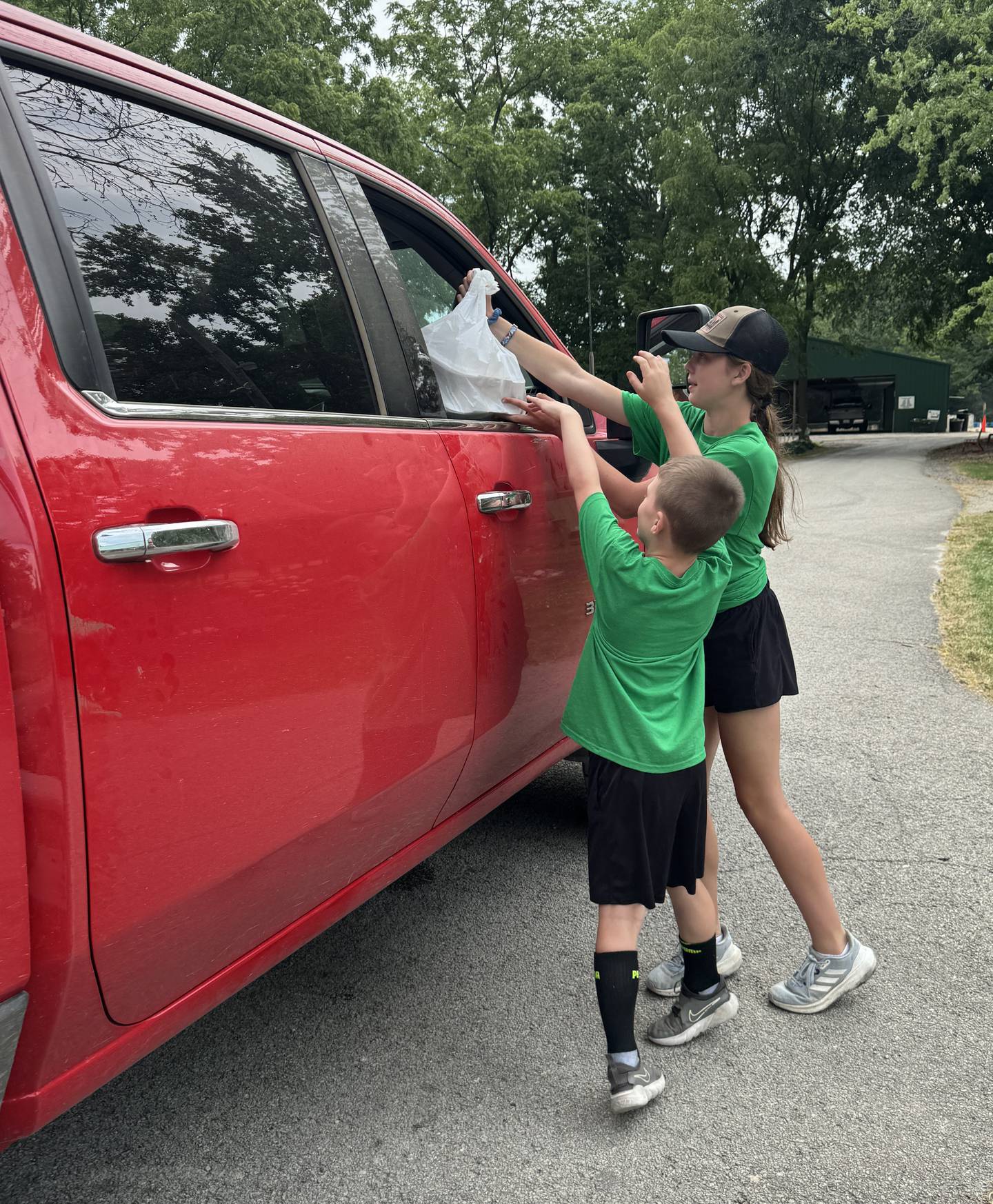 4-H youth deliver a meal to a car during the Illinois Extension and Kendall County 4-H Foundation’s annual pork chop dinner fundraiser on Thursday, June 20.