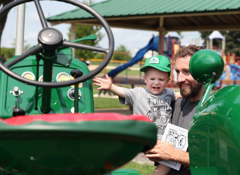 Rowan Wessels, 2, from DeKalb, tries to get his dad Brandon to let him sit on a 1950 Oliver 88 Rowcrop Gas tractor on display Saturday, July 15, 2023, at the Waterman Lions Summerfest and Antique Tractor and Truck Show at Waterman Lions Club Park.