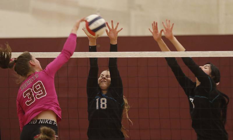 Richmond-Burton's Maggie Uhwat tries to hit the ball through the block of Woodstock North’s Gabriella Schefke (center) and Daniela Medina during a Kishwaukee River Conference volleyball match Wednesday, Oct.11, 2023, at Richmond-Burton Community High School.