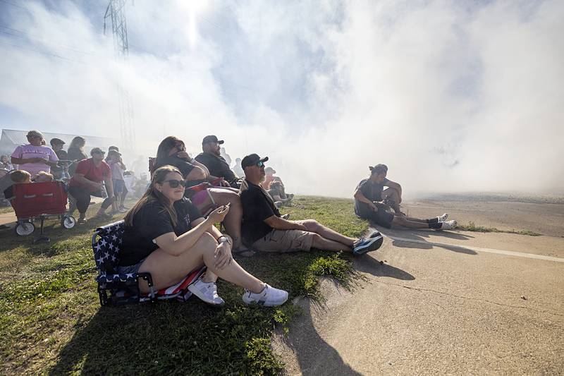 Visitors sit enveloped in smoke from the burning rubber Monday, June 10, 2024 in Rock Falls.