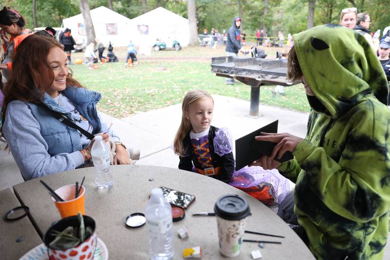 Emma checks out her face tattoo as her mother Lauren watches at the Hayride of Horrors on Monday, Oct. 14, 2024 at Dellwood Park in Lockport.