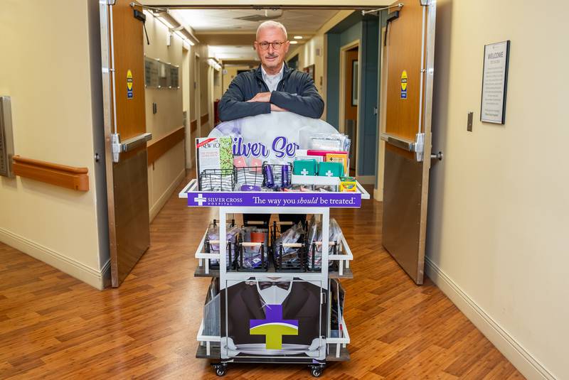 Silver Cross Volunteer Mark Sylvester pushes the Silver Service Cart throughout the hospital offering convenience items such as puzzle books and reading glasses to patients. Rotary Club of Joliet funded the cart and Holy Club of Joliet stocked the cart.