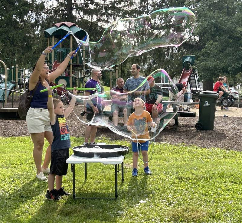 Fabi DeForge of Rockford makes a huge bubble as Russell and Henry Coy, 5 and 6, of German Valley watch during Jason Kollom's "The Bubble Guy" event during German Valley Days  on Saturday, July 20, 2024.