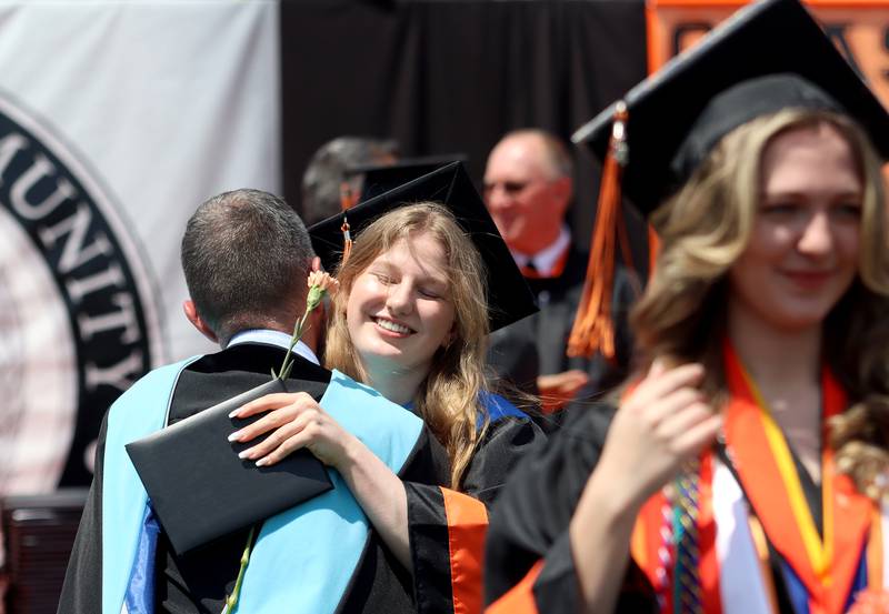 Reilly Byron receives a hug after getting her diploma as McHenry High School held its 104th Annual Commencement at McCracken Field on Saturday.