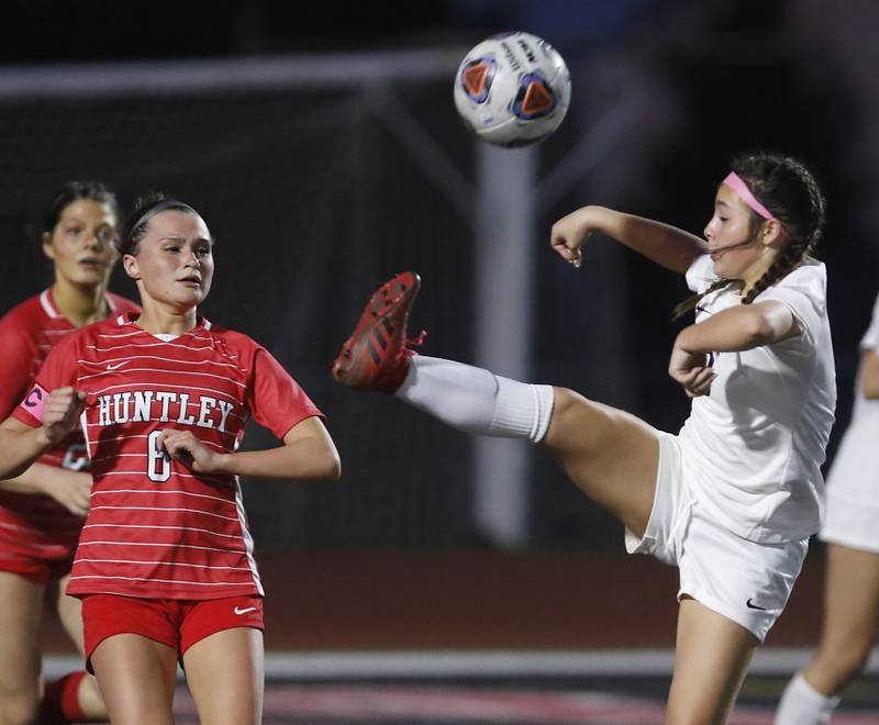 McHenry's Elena Carlos kicks the ball away from Huntley’s Grace Helzer during a Fox Valley Conference soccer match Thursday, April 13, 2023, at Huntley High School.