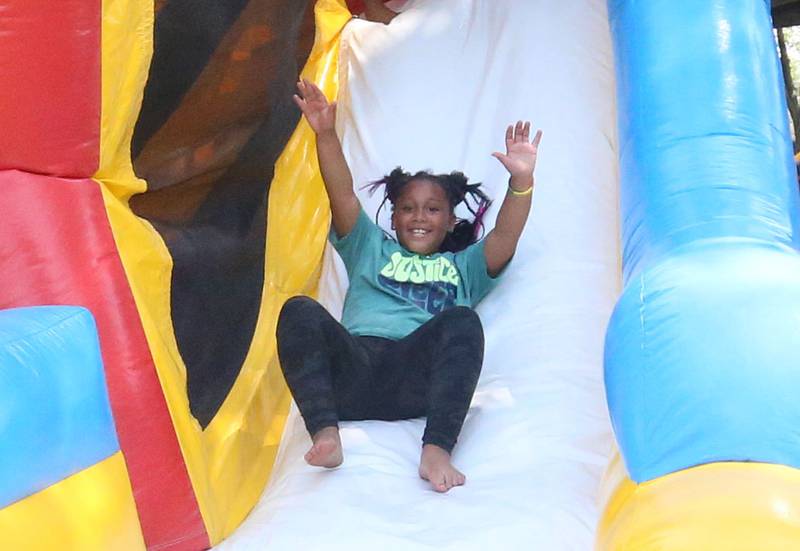 I'zzonah Fantroy slides down a bounce house slide during the Juneteenth event on Wednesday June 19, 2024 at Kirby Park in Spring Valley. The four-hour event incuded basketball, food and drinks, music, bounce houses and more. Juneteenth, the federal holiday commemorates June 19, 1865, when enslaved people from Galveston, Texas learned they had ben freed, which came two years after the Emancipation Proclamation was issued.