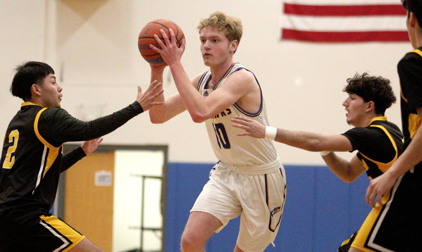 Johnsburg’s Ben Person navigates traffic against Harvard in varsity boys basketball at Johnsburg Saturday.