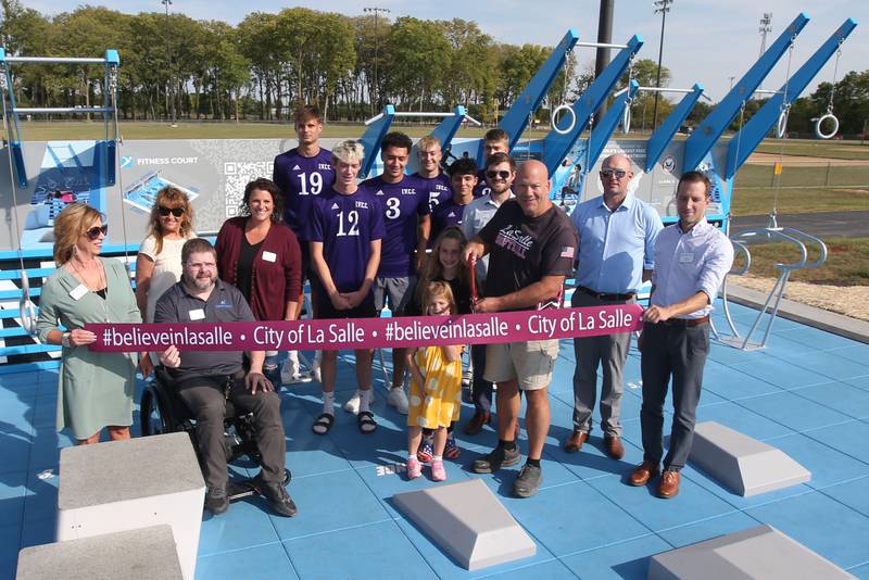 La Salle mayor Jeff Grove (third from right) cuts a ribbon during a grand opening of a new outdoor fitness court on Wednesday, Sept, 18, 2024 at Rotary Park in La Salle. This Fitness Court was developed by Blue Cross and Blue Shield of Illinois, City of La Salle and National Fitness Campaign to expand free access to high quality workouts and create equitable access to exercise for communities around the state. The Fitness Court is the world’s best outdoor gym that lets people use their own body weight to get a complete workout using seven exercise stations. This opportunity was possible through an Open Land and Spaces Development (OSLAD) Grant from the State of Illinois IDNR.