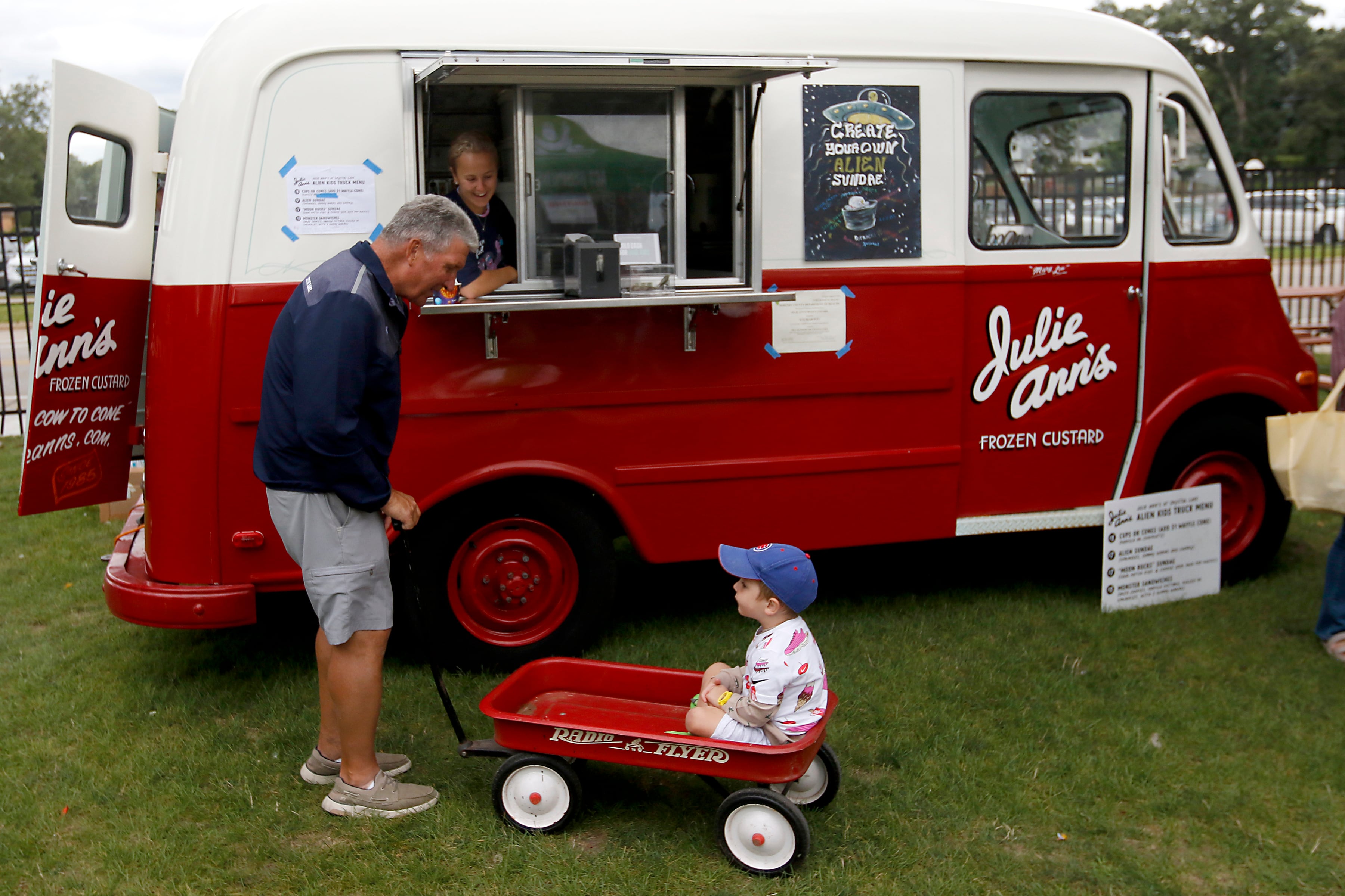 MacKenna Morris, inside the truck, talks with Jack Streit, 3, and his grandfather John Streit and the get custard from Julie Ann’s Frozen Custard during the Ice Cream Fest on Friday, Aug. 9, 2024, at Crystal Lake’s Main Beach. The second annual event featured music, ice cream venders and an ice cream eating contest.