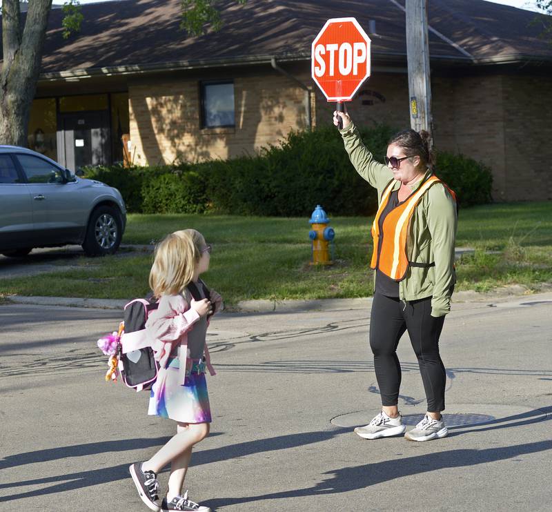 Crossing Guard Amy Anderson helps students cross McKinley Road as the first day of school began Wednesday, Aug. 21, 2024, at McKinley School in Ottawa.