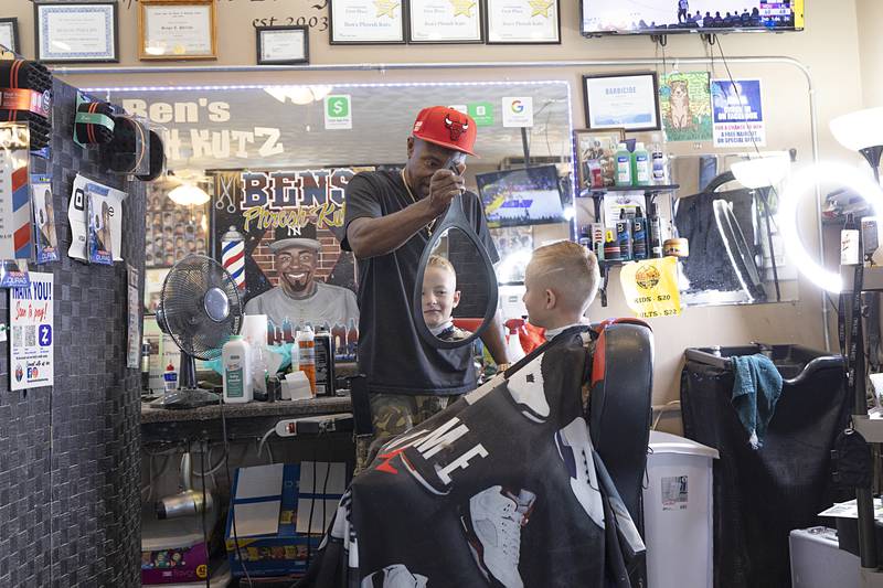 Ben Phillips shows Colton Lee, 7, his new cut Tuesday, July 30, 2024. Phillips will have four barbers and four stylists on staff for the Aug. 11 Back 2 School Bash. Doors open at 1 p.m.