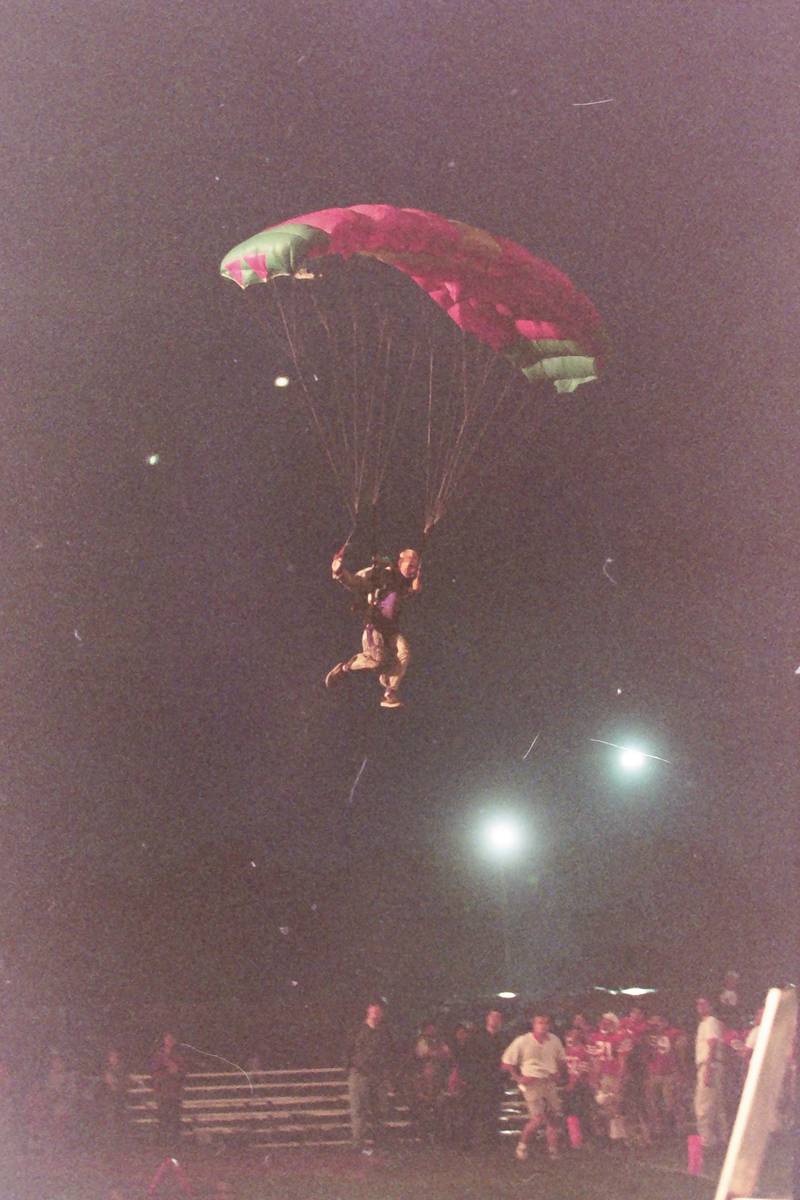 A skydiver brings in the game ball as he parchutes onto King Field during the 100th year Gridiron Game on Friday, Sept, 25, 1998 at King Field.