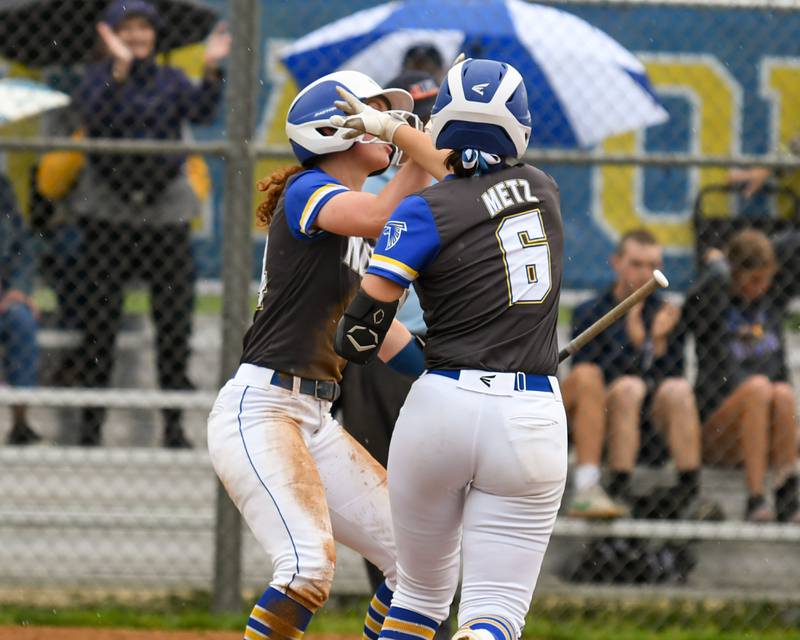 Wheaton North's Monica Kading, left, celebrates with teammate Erin Metz (6) after Monica scored a run during the game on Monday May 13, 2024, as they took on Glenbard North High School.