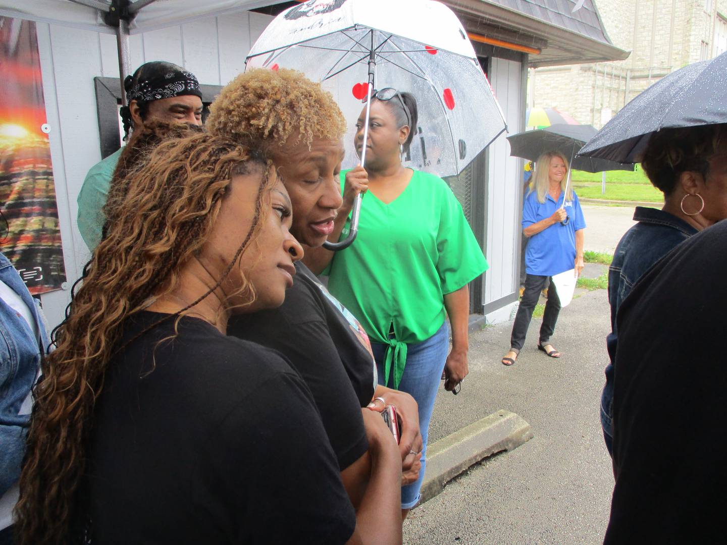 Latisha Fox (left) shares a moment with Deneen Ford before the start of a ceremony on Saturday, to unveil a new street sign dedicating a section of Joliet Street in Joliet as Louise Coleman Drive. Aug. 17, 2024