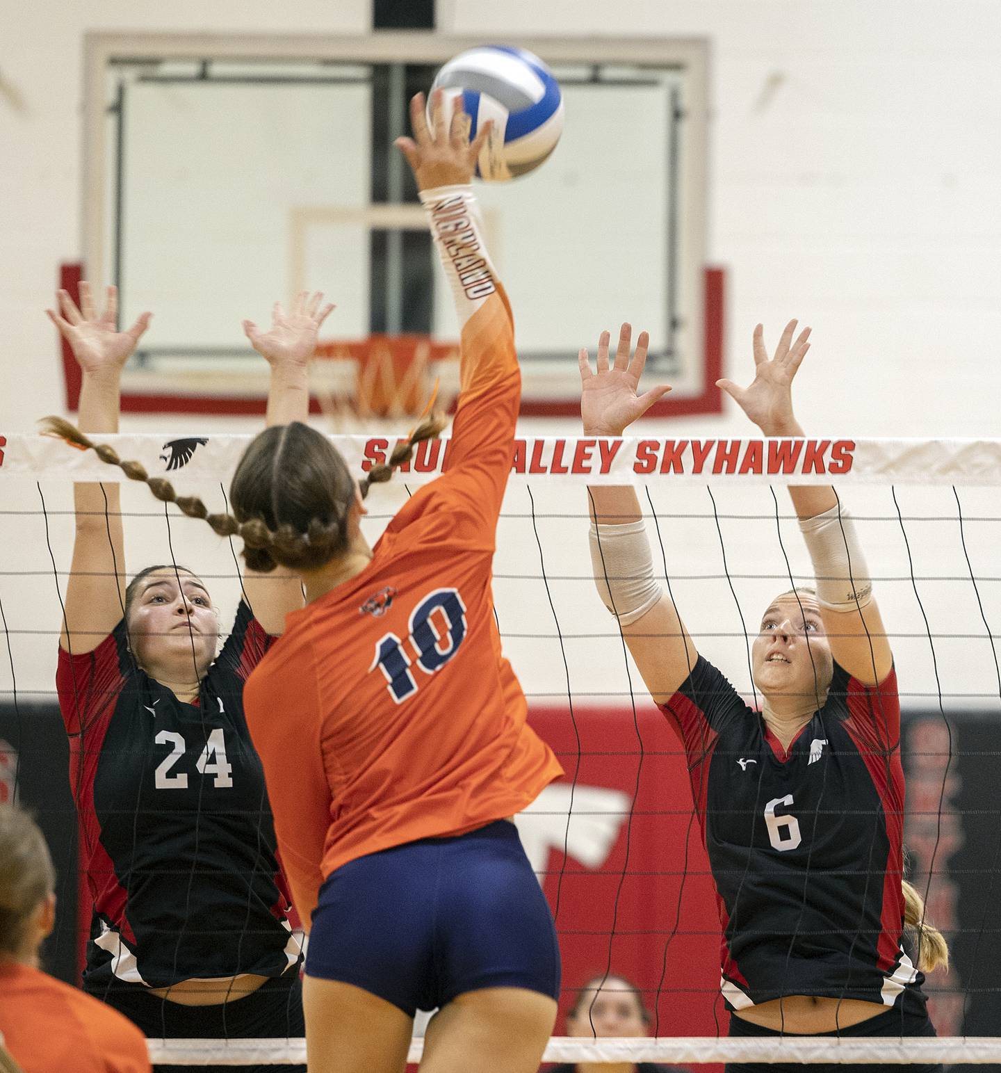 Sauk Valley’s Maggie Richetta (left) and Jess Johns work the net against Highland’s Taryn Mathews Tuesday, Sept. 17, 2024.