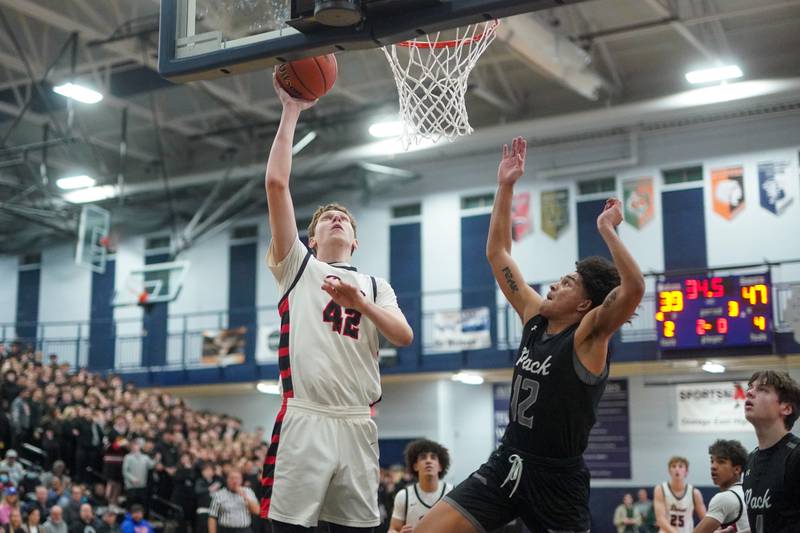 Benet’s Colin Stack (42) shoots the ball in the post against Oswego East's Drey Wisdom (12) during a Class 4A Oswego East regional final basketball game at Oswego East High School on Friday, Feb 23, 2024.