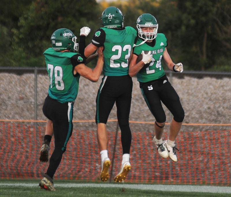 Seneca's Brody Rademacher (24) celebrates with teammates Memphis Echeverria (78) and Brady Sheedy after scoring the first touchdown against Lisle at Seneca on Friday, Sept. 6, 2024.