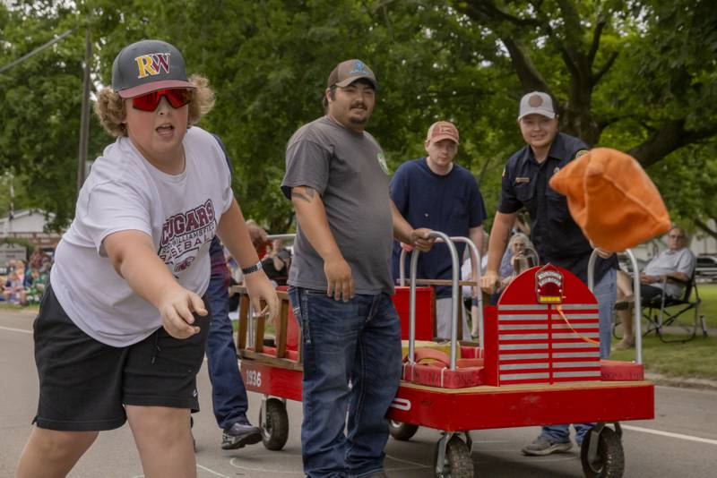 Hunter Gott throws a bean bag at the midway point of the bed races Saturday, June 8, 2024, at the Buffalo Days in La Moille.