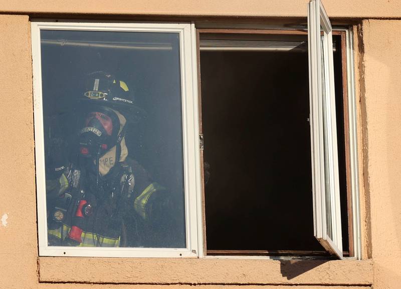 A firefighter tries to open a window to vent smoke at the site of a structure fire Friday, Sept. 1, 2023, in the building that once housed Fanatico Italian restaurant at 1215 Blackhawk Road in DeKalb.