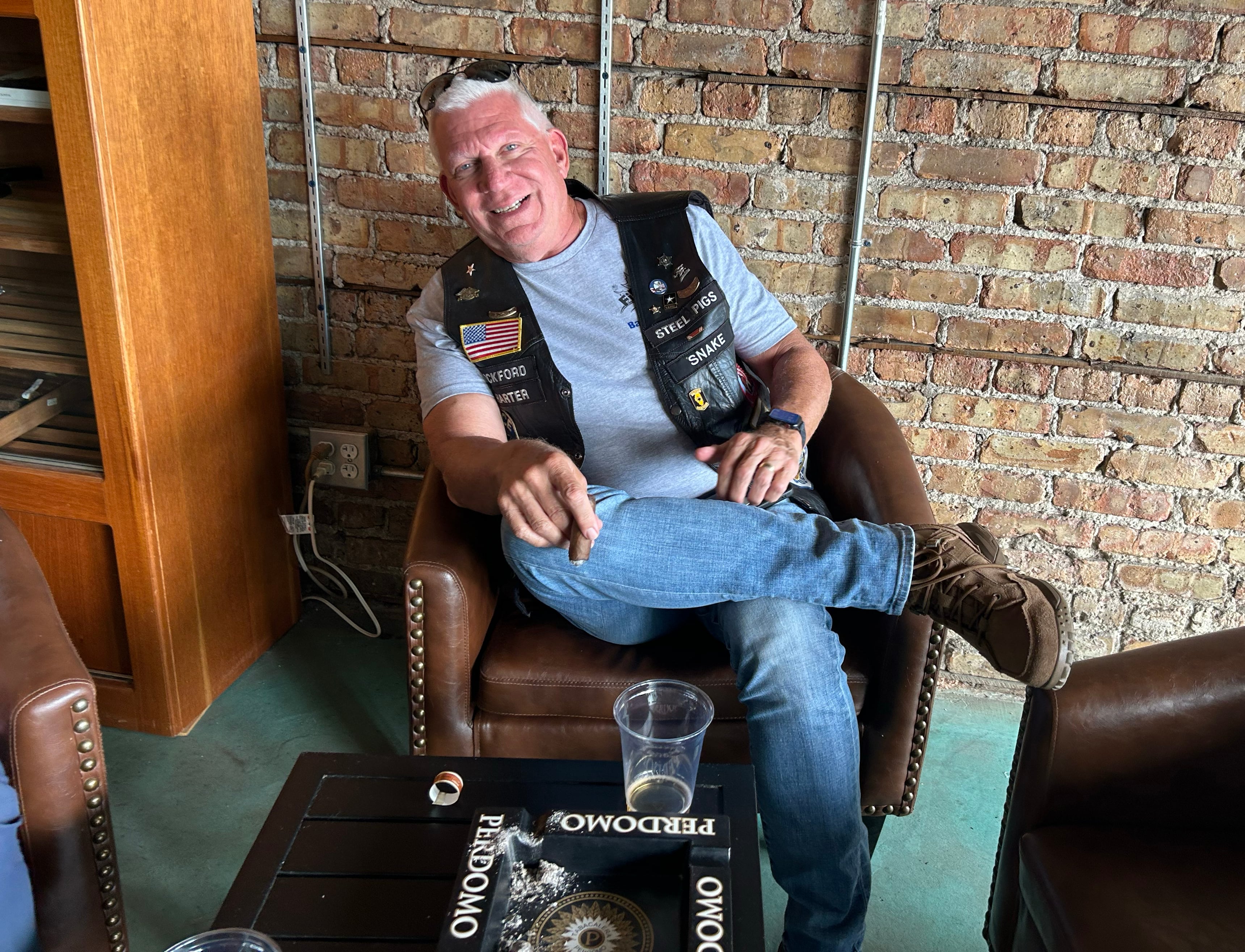 Winnebago County Sheriff Gary Caruana enjoys a cigar in the lounge at Bad Ash Cigars during the Back the Blue Motorcycle Rally on Saturday, Aug. 17, 2024 in Oregon. Caruana was one of the riders that took part in the ride.