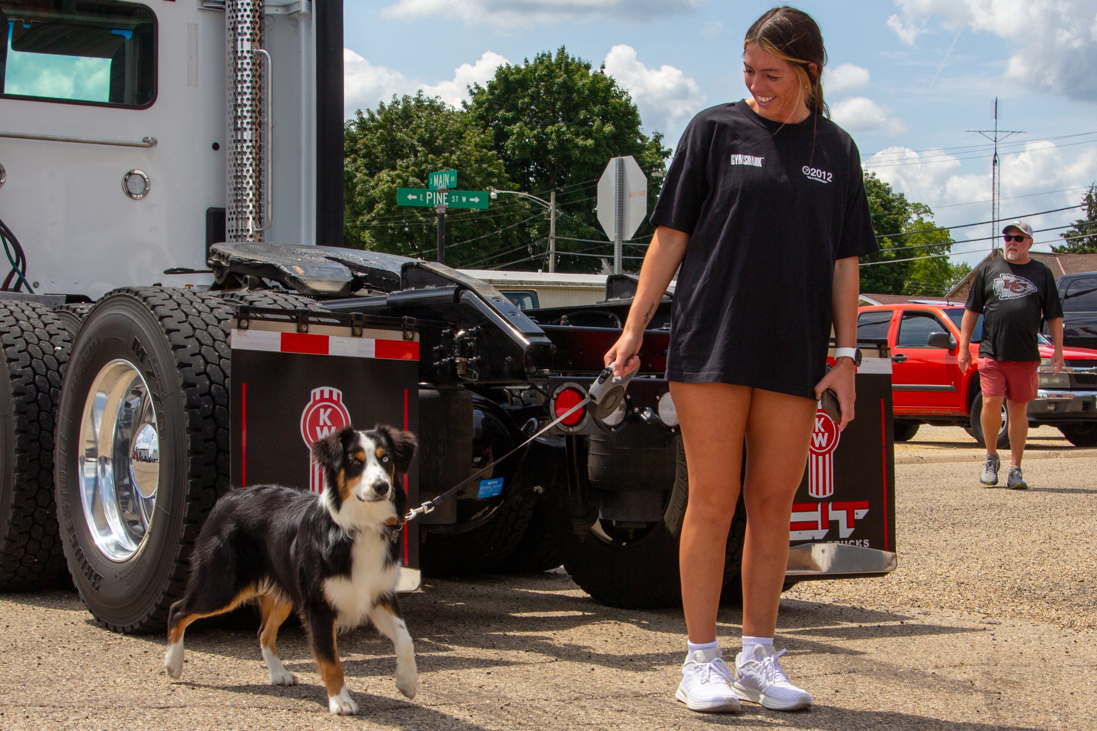 Women walks dog on Saturday, July 20, 2024 at the Convoy Against Cancer Big Truck Show on Main Avenue in Ladd.