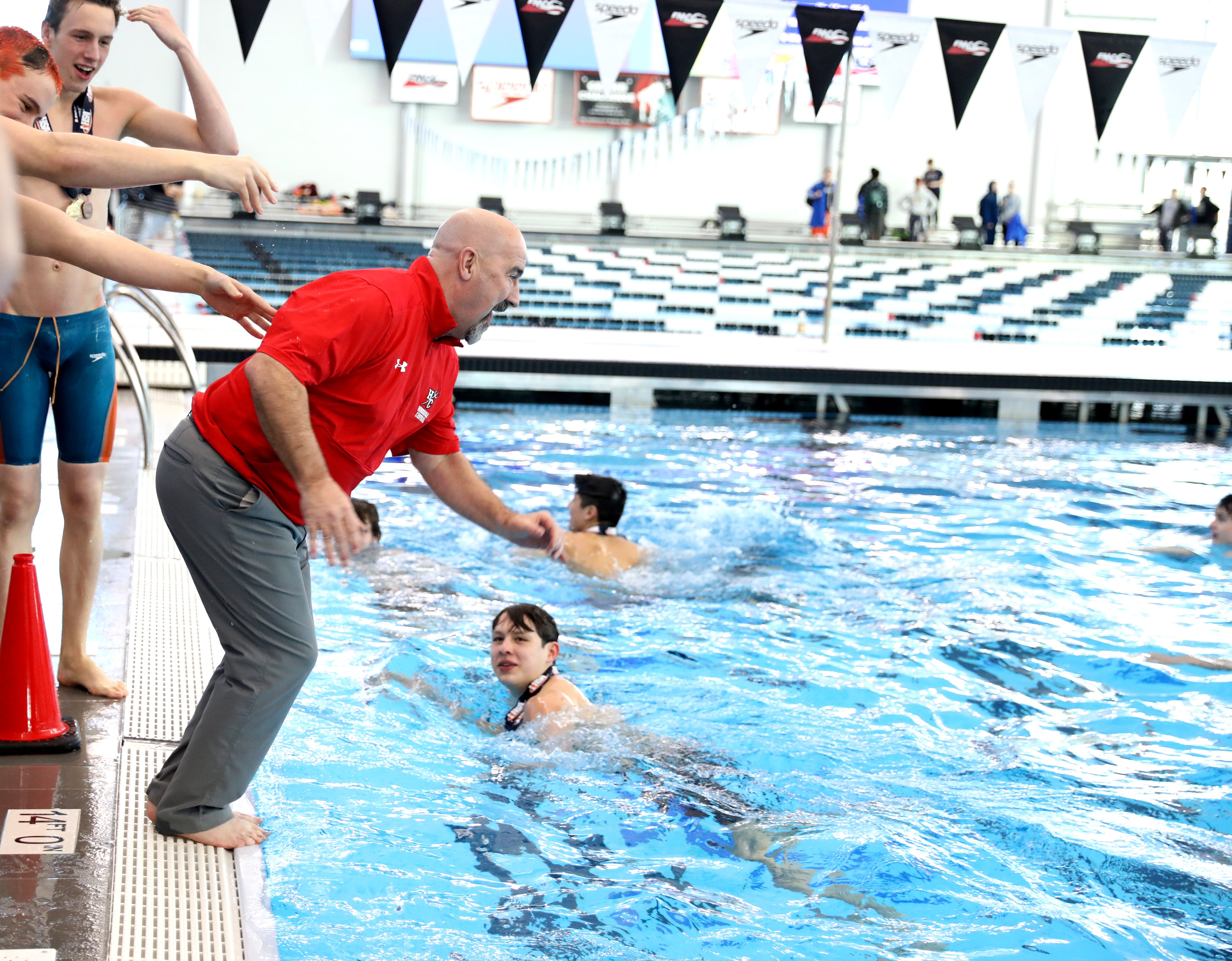 Hinsdale Central Athletic Director Dan Jones jumps into the water following the IHSA Boys State Championships at FMC Natatorium in Westmont on Saturday, Feb. 25, 2023.