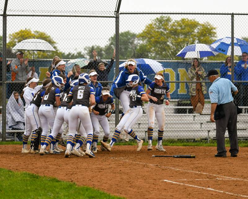 Wheaton North's Reagan Crosthwaite (21) gets congratulated by teammates after hitting a home run during the game on Monday, May 13, 2024, while taking Glenbard North.